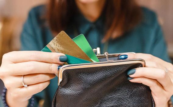 Surprised woman taking out from wallet two credit cards