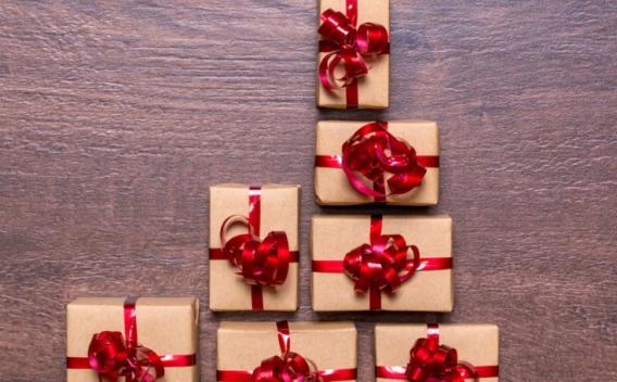 Creative concept with gift boxes Christmas tree of gifts on a wooden table