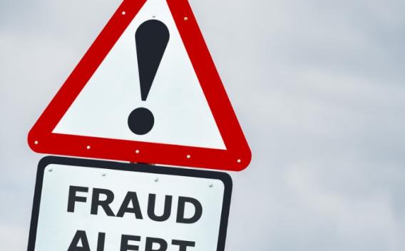 fraud alert warning road sign against stormy sky