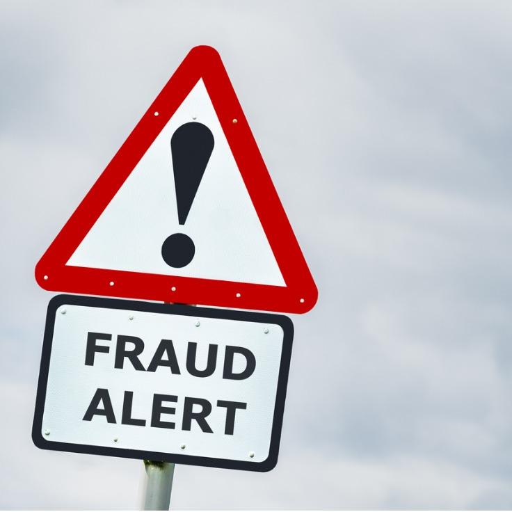 fraud alert warning road sign against stormy sky