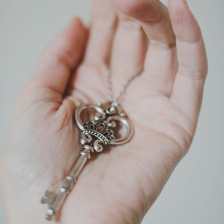 A fancy key resting in a person's open palm