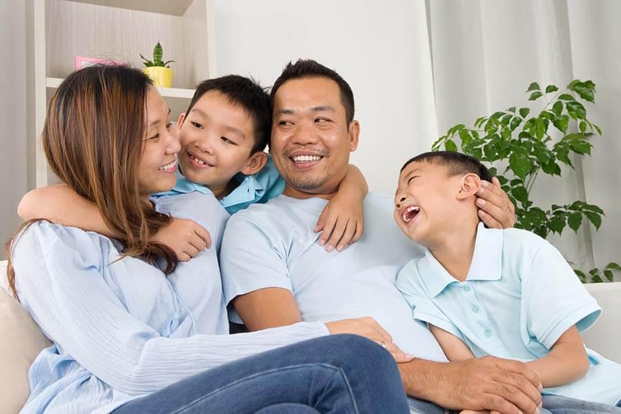 A family embracing on a couch and smiling