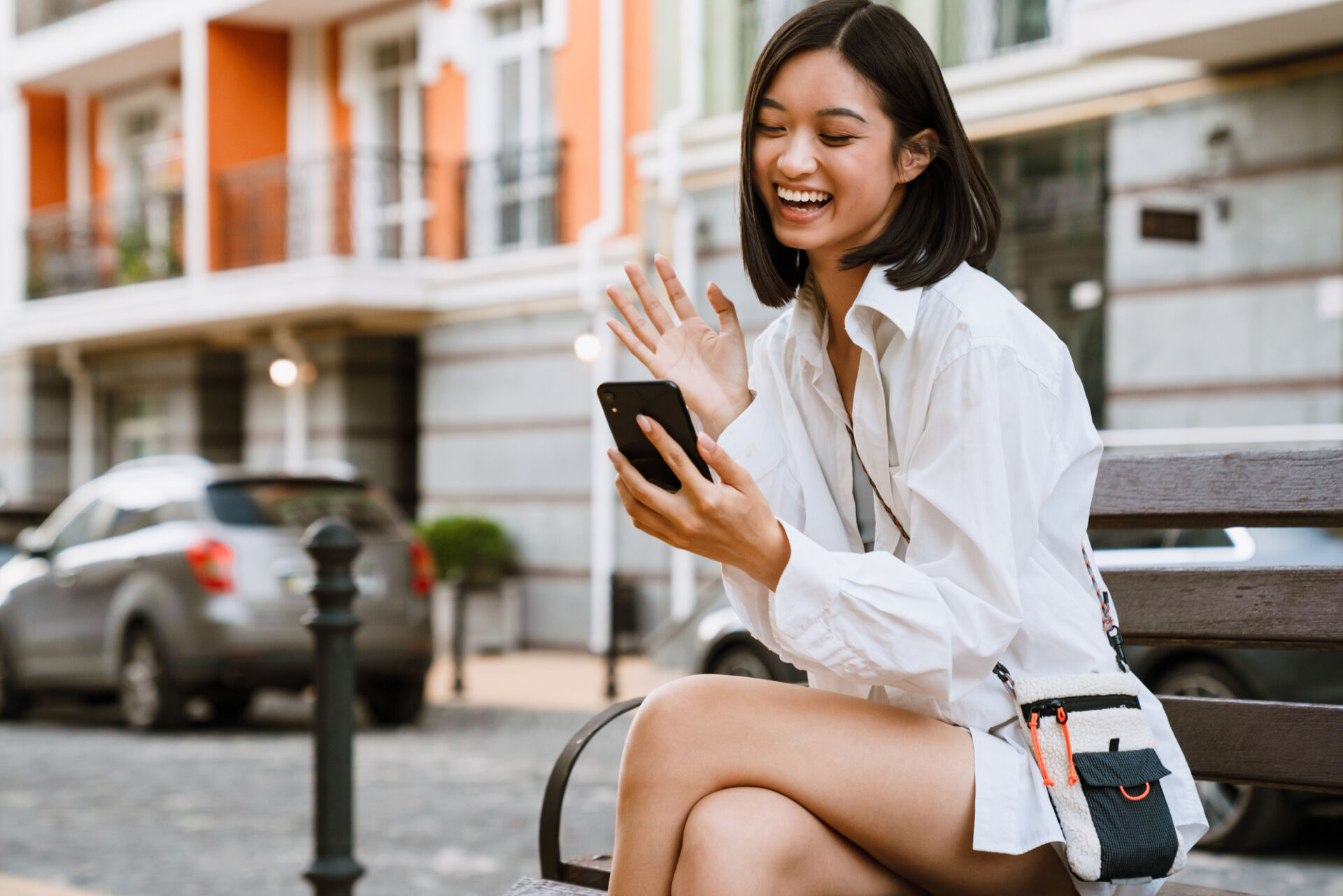 A young woman excitedly manages her second chance checking account from her smartphone.