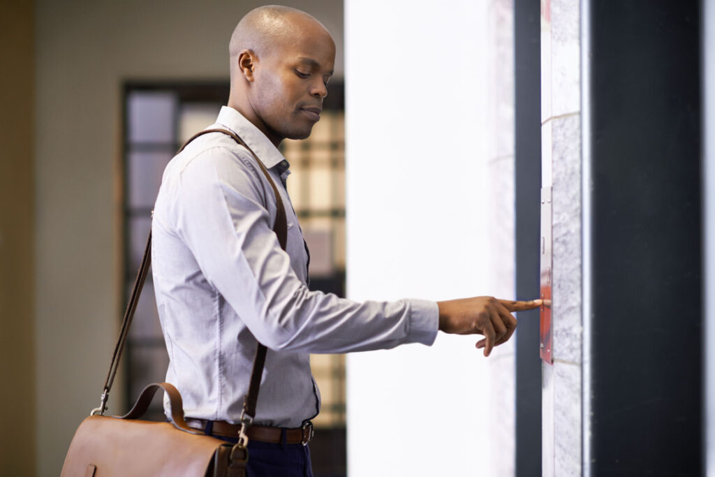 A man confidently enters an office elevator, symbolizing a fresh start with a second chance checking account.