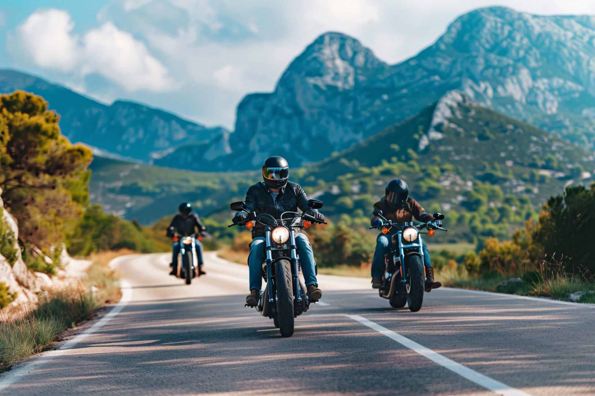 Three bikers ride their motorcycles on a winding road.