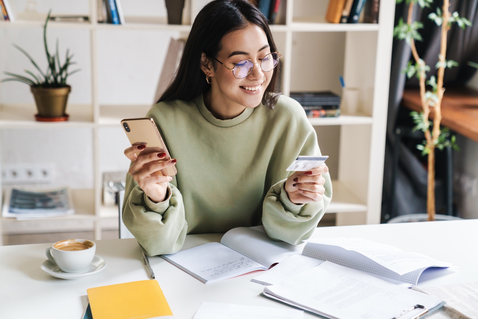 A young college student checks her credit card balance on her smartphone.